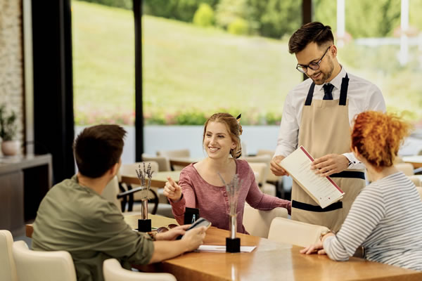 Waiter sedang melayani tamu secara manual menggunakan kertas